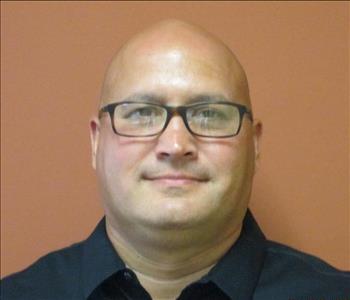 SERVPRO bald male employee with dark eyes and glasses