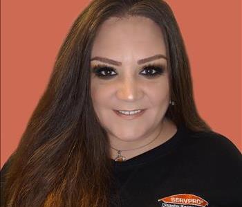 Female SERVPRO employee with dark eyes and hair smiling infront of white background